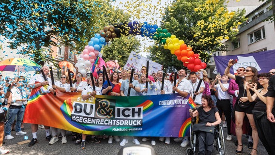 Hamburgs Erster Bürgermeister Peter Tschentscher (SPD, M), Katharina Fegebank (Grüne, l. neben Tschentscher), Zweite Bürgermeisterin von Hamburg, und Iryna Tybinka (r. neben Tschentscher), Generalkonsulin der Ukraine in Hamburg, starten die Demonstration zum Christopher Street Day (CSD) mit einem Konfetti-Regen. © picture alliance/dpa Foto: Markus Scholz