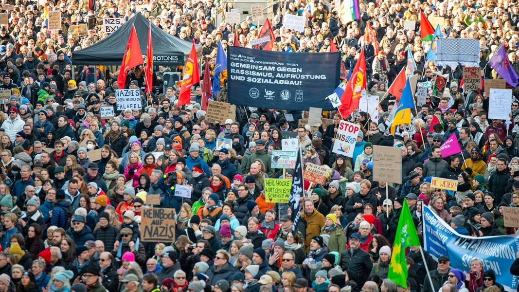 Viele Menschen in Hamburg demonstrieren mit Fahnen und Plakaten gegen Rechtsextremismus.