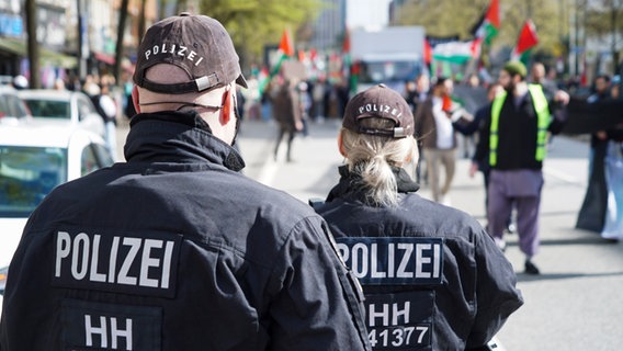 Ein Polizist und eine Polizistin beobachten eine Pro-Palästina-Demo in Hamburg. © picture alliance / ABBfoto 