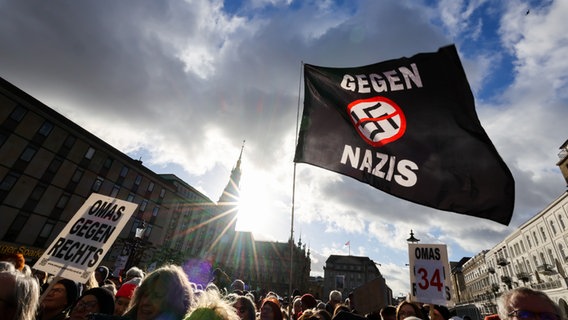 Teilnehmende einer Demonstration in Hamburg halten eine Flagge mit der Aufschrift "Gegen Nazis" hoch. © picture alliance / dpa Foto: Christian Charisius