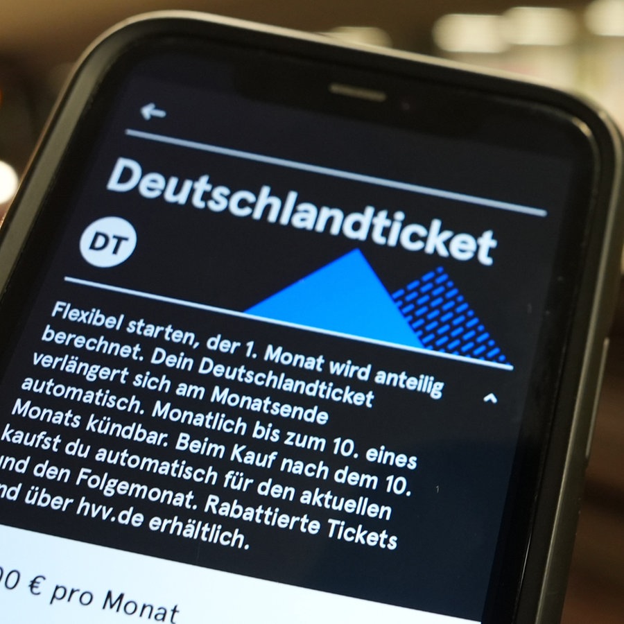 Ein Fahrgast hält ein Smartphone mit einem digitalen Deutschlandticket an einer U-Bahn-Station in der Hand. © picture alliance / dpa Foto: Marcus Brandt