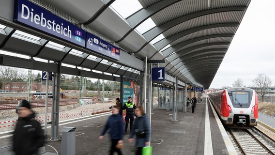 Fahrgäste sind auf dem Bahnhof der S-Bahnstation Diebsteich in Hamburg unterwegs. Sie wurde nach einem Umbau wiedereröffnet. © picture alliance / dpa Foto: Christian Charisius