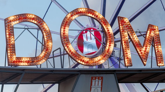 Der Schriftzug "DOM" leuchtet am ersten Tag des Hamburger Frühlingsdoms. © Markus Scholz/dpa 