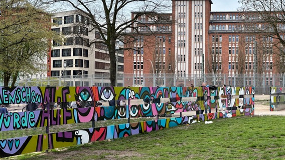 Ein bunt bemalter Sichtschutz vor der Drogeneinrichtung Drob Inn in Hamburg. © NDR Foto: Alexander Heinz