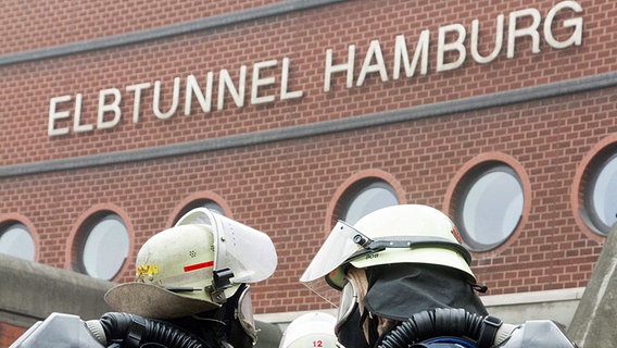 Feuerwehrleute mit Atemschutzgeräten vor dem Elbtunnel in Hamburg in Sicherheit. © dpa Foto: Sven Jörgens