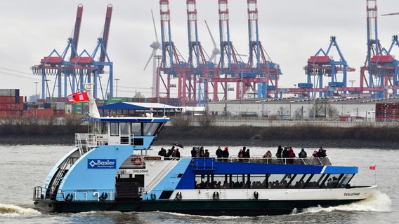 Eine Fähre fährt im Hamburger Hafen an Hafenkränen vorbei. © picture alliance / dpa Foto: Soeren Stache