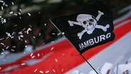 Fans des FC St. Pauli halten im Stadion eine Flagge mit Totenkopf und der Aufschrift "Hamburg" © picture alliance 