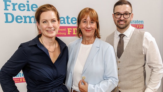 Sonja Jacobsen, Katarina Blume und Sami Musa von der Hamburger FDP stehen nebeneinander. © Markus Scholz/dpa 