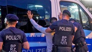 Beamte der Bundespolizei durchsuchen einen Mann am Hamburger Hauptbahnhof. © picture alliance / 