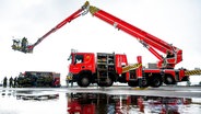 Ein neues Teleskopmastfahrzeug (TMF) der Feuerwehr Hamburg mit einer Höhe von 70 Metern steht während einer Präsentation am Hafen. © Daniel Bockwoldt/dpa 