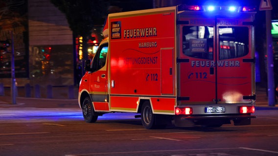 Ein Krankenwagen der Hamburger Feuerwehr fährt mit Blaulicht zu einem Einsatz. © picture alliance Foto: Maximilian Koch