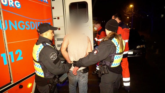 Hamburger Polizisten führen in Ohlsdorf einen mit Handschellen gefesselten Mann ab. © TeleNewsNetwork Foto: Screenshot