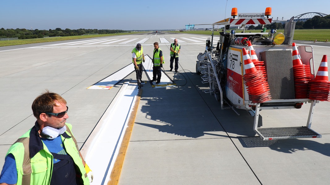 Mitarbeiter des Wartungs- und Instandhaltungsteams erneuern die Markierungen auf einer der beiden Start- und Landebahnen am Hamburger Flughafen.