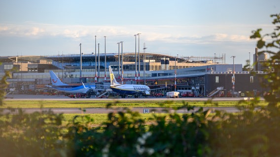 Zwei Flugzeuge stehen vor einem Terminal des Hamburger Flughafens. © Jonas Walzberg/dpa Foto: Jonas Walzberg