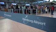 Flugpassagiere stehen an den Check-in-Schaltern in der Abflughalle des Hamburg Airports Schlange. © picture alliance Foto: Marcus Brandt