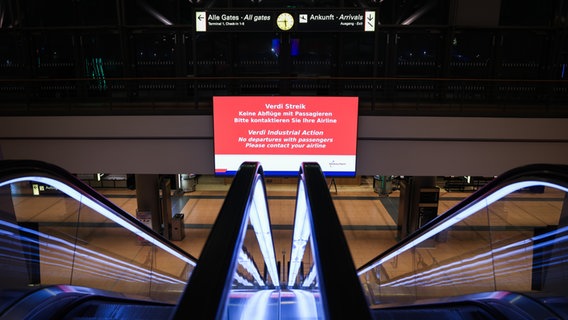 Auf einem Bildschirm stehen Informationen zum Warnstreik am Flughafen Hamburg. © dpa Foto: Christian Charisius