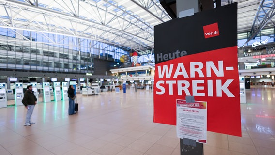 Ein Schild mit der Aufschrift "Warnstreik" hängt im Terminal 1 im Flughafen Hamburg. © Christian Charisius 