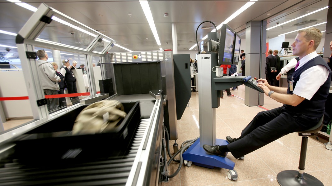 Ein Sicherheitsbeamter sitzt an einer neuen Kontrollstelle im Sicherheitsbereich des Hamburger Flughafens vor einem Monitor.
