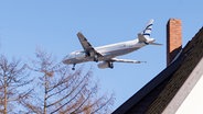 Ein Flugzeug über einem Wohnhaus im Hamburger Stadtteil Niendorf. © picture alliance / dpa Foto: Daniel Bockwoldt