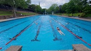 Schwimmerinnen und Schwimmer ziehen ihre Bahnen im Hamburger Kaifu-Freibad. © NDR Foto: Karsten Sekund