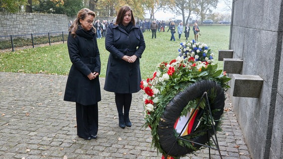 Carola Veit (l.), Bürgerschaftspräsidentin, und Katharina Fegebank, Zweite Bürgermeisterin von Hamburg, nehmen anlässlich des Volkstrauertags an einer Kranzniederlegung am Internationalen Mahnmal in der KZ-Gedenkstätte Neuengamme zum Gedenken an die Opfer von Krieg und Gewalt teil. © picture alliance / dpa Foto: Georg Wendt