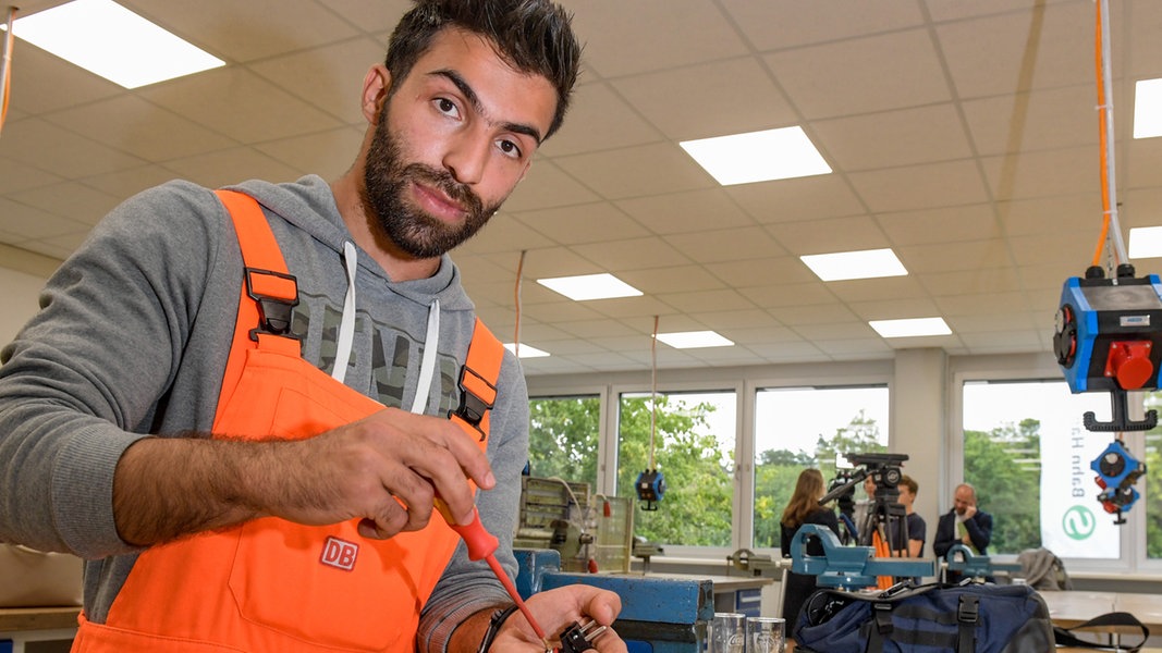 Ein Geflüchteter aus Syrien zeigt erste Lehrtätigkeiten an seinem Arbeitsplatz bei der Deutschen Bahn in Hamburg.