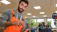 Ein Geflüchteter aus Syrien zeigt erste Lehrtätigkeiten an seinem Arbeitsplatz bei der Deutschen Bahn in Hamburg. © picture alliance/dpa Foto: Axel Heimken