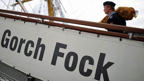 Ein Besatzungsmitglied des Segelschulschiffs "Gorch Fock" trägt in Hamburg einen Sack Kartoffeln an Bord. © dpa Foto: Angelika Warmuth