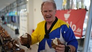 Ein Mann hält eine zerteilte Kokosnuss in seiner Hand. © dpa Bildfunk Foto: Marcus Brandt