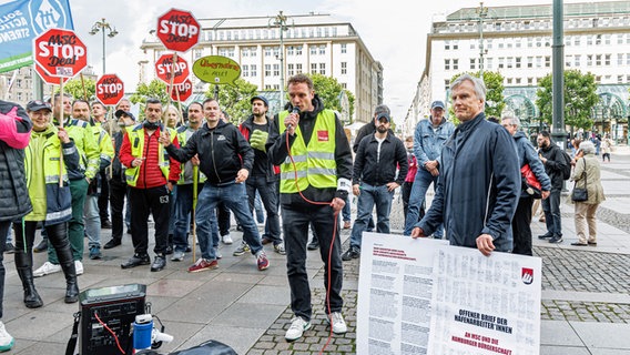 Hafenarbeiter übergeben einen Offenen Protestbrief an Mathias Petersen (r., SPD), den Vorsitzenden des Haushaltsausschusses der Bürgerschaft. © picture alliance/dpa Foto: Markus Scholz