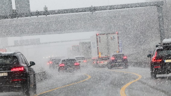 Fahrzeuge sind bei starkem Schneefall auf der Autobahn A7 bei Hamburg unterwegs. © dpa-Bildfunk Foto: Christian Charisius