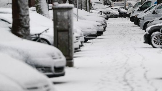 Schneebedeckte Fahrzeuge parken in einer Nebenstraße. © dpa-Bildfunk Foto: Christian Charisius