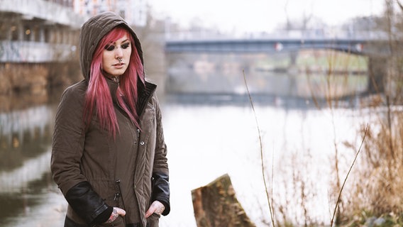 Eine Frau steht alleine an einem Kanal. © picture alliance / Zoonar Foto: Axel Bueckert