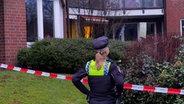 Eine Polizistin steht vor einem Tatort im Hamburger Stadtteil Bramfeld. © News5 