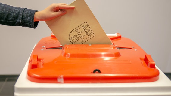 Jemand wirft Wahlunterlagen zur in Hamburg in eine Wahlurne. © NDR Foto: Zeljko Todorovic