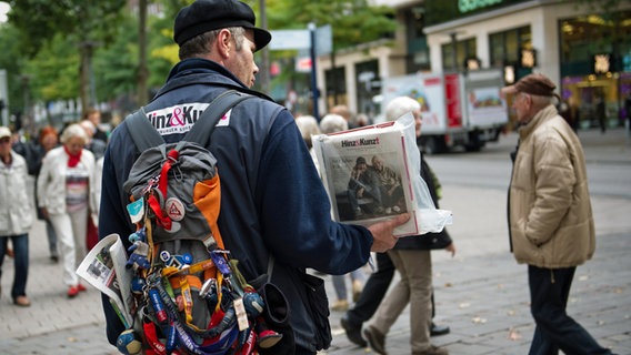 Ein ehemaliger Obdachloser verkauft vor einem Kaufhaus in Hamburg das Straßenmagazin "Hinz & Kunzt". © picture alliance / dpa Foto: Maja Hitij