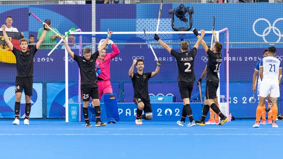 Mehrere deutsche Hockey-Spieler jubeln, darunter die Hamburger Hannes Müller (Trikotnummer 25) und Mathias Müller (Trikotnummer 2). © picture alliance / SvenSimon Foto: Volker Essler