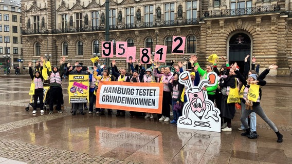 Vertreter der Volksinitiative "Hamburg testet Grundeinkommen" jubeln auf dem Hamburger Rathausmarkt über 95.842 gesammelte Unterschriften. © picture alliance / dpa Foto: Markus Klemm