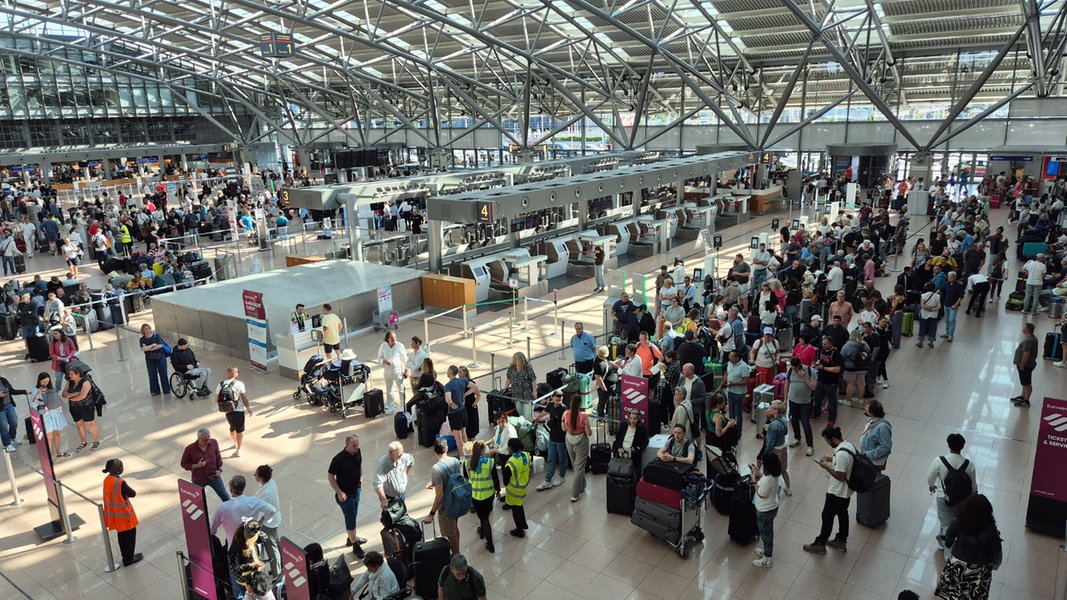 Menschen warten am Airport Hamburg wegen IT-Problemen.