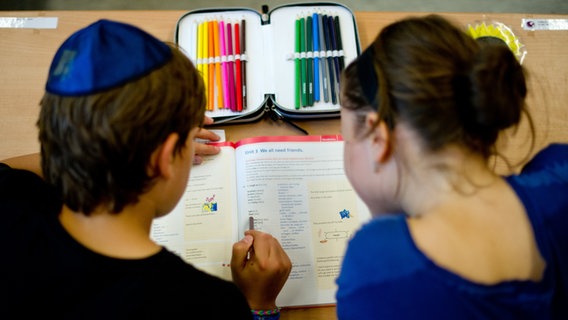 Ein Schüler und eine Schülerin der Talmud-Tora-Schule schauen am 12.09.2014 in Hamburg in ein Schulheft. © dpa/picture allaince Foto: Daniel Bockwoldt