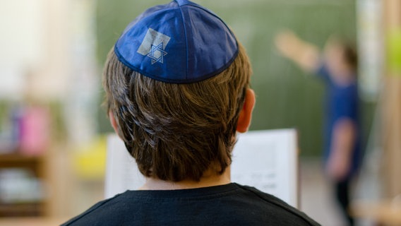 Ein Junge mit Kippa sitzt in einer Hamburger Schule im Unterricht © picture alliance Foto: Daniel Bockwoldt