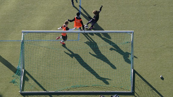 Kinder spielen auf einem Kunstrasenplatz in Hamburg Fußball. © picture alliance / dpa Foto: Marcus Brandt
