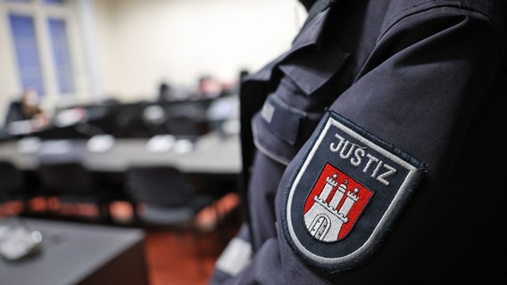 Eine Justizbeamtin steht zu Beginn eines Prozesses in einem des Hamburger Strafjustizgebäudes. © picture alliance/dpa Foto: Christian Charisius