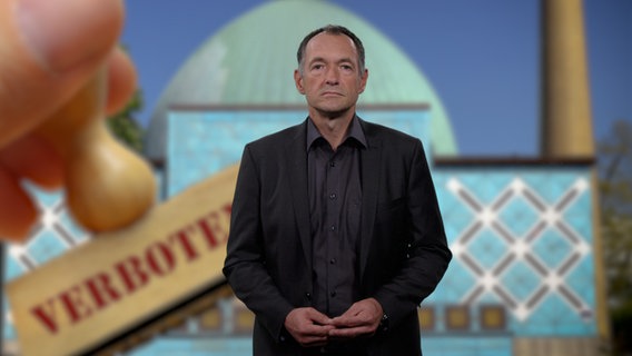 Peter Kleffmann steht vor einem Bild der Blauen Moschee. © NDR 