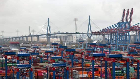 Container lagern auf dem Containerterminal Burchardkai im Hamburger Hafen. Im Hintergrund ist die Köhlbrandbrücke zu sehen. © Christian Charisius/dpa 