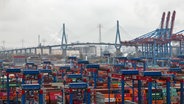 Container lagern auf dem Containerterminal Burchardkai im Hamburger Hafen. Im Hintergrund ist die Köhlbrandbrücke zu sehen. © Christian Charisius/dpa 