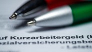 Zwei Kugelschreiber liegen auf einem Antragsformular für Kurzarbeitergeld. © ZB Foto: Jens Büttner