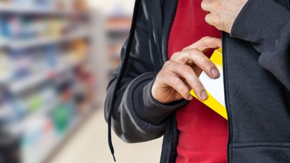 Ein Person stiehlt ein Produkt in einem Supermarkt. (Symbolfoto) © IMAGO / Panthermedia 