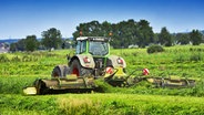 Ein Landwirt fährt im Hamburger Stadtteil Kirchwerder mit seinem Traktor auf einem Feld. © picture alliance / CHROMORANGE 