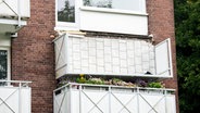 Ein abgestürzter Balkon hängt an einem Mehrfamilienhaus im Hamburger Stadtteil Langenhorn. © Daniel Bockwoldt/dpa 